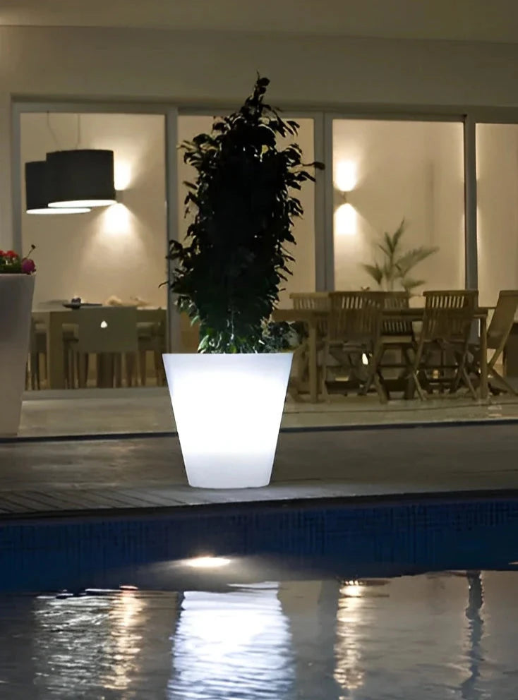 Pot Cono LED Vondom allumé au bord d'une piscine, la nuit