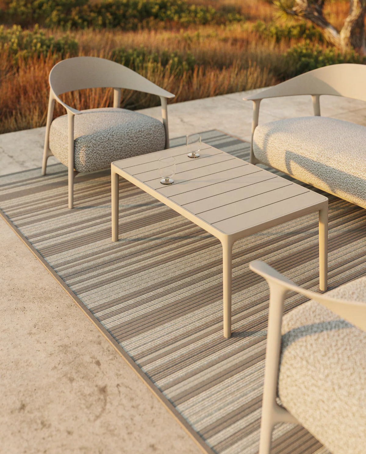 Sillones, sofá y mesa auxiliar Africa Vondom en crudo sobre una alfombra de rayas, terraza de piedra