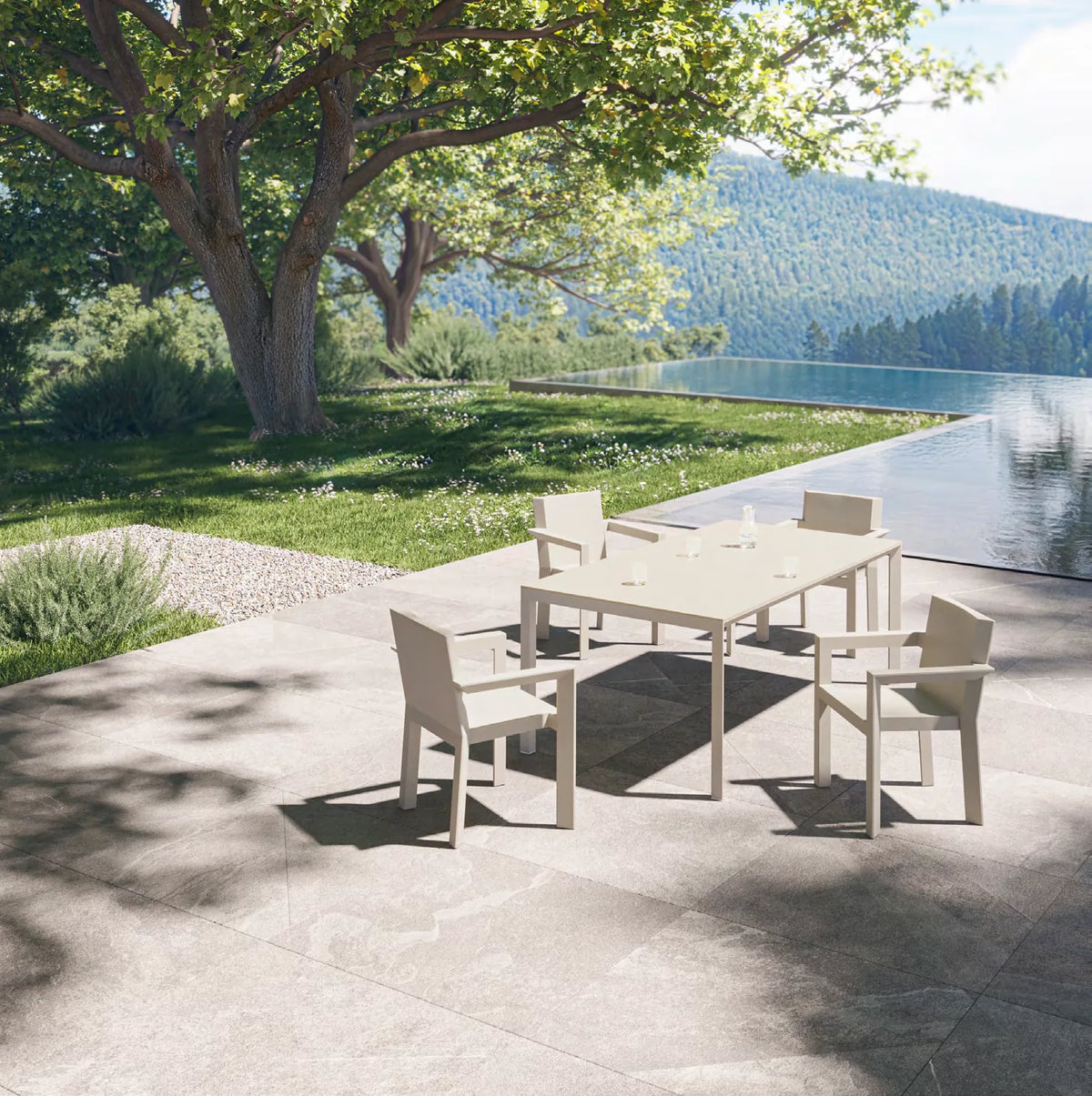 Chaises Frame écrues autour d'une table à rallonges fermée, terrasse au bord d'une piscine à débordement