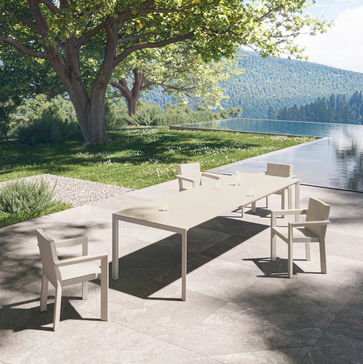 Chaises Frame écrues autour d'une grande table à rallonges déployée, vue sur la montagne
