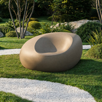 Fauteuil double Stone Vondom taupe vu de trois quarts sur l'herbe, entouré de buis