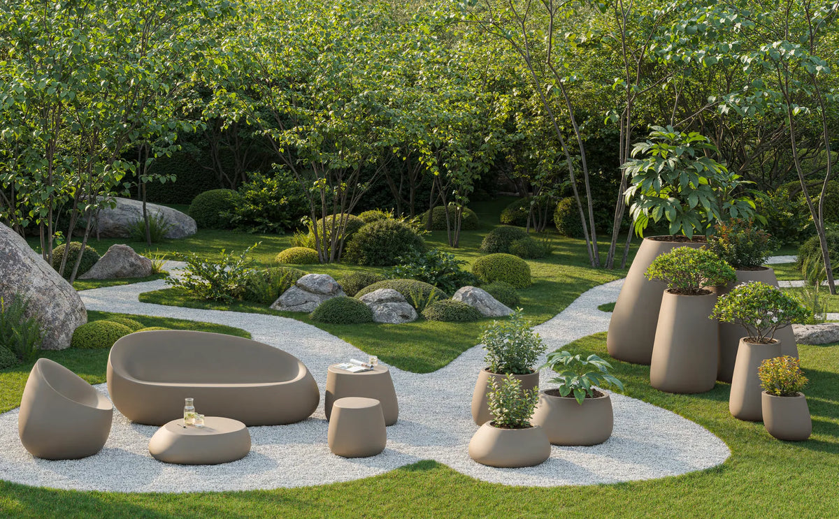 Jardin avec chemin de gravier : fauteuil, canapé, table basse, table d'appoint, pouf et pots Stone Vondom taupe